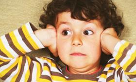 image of distressed child covering ears
